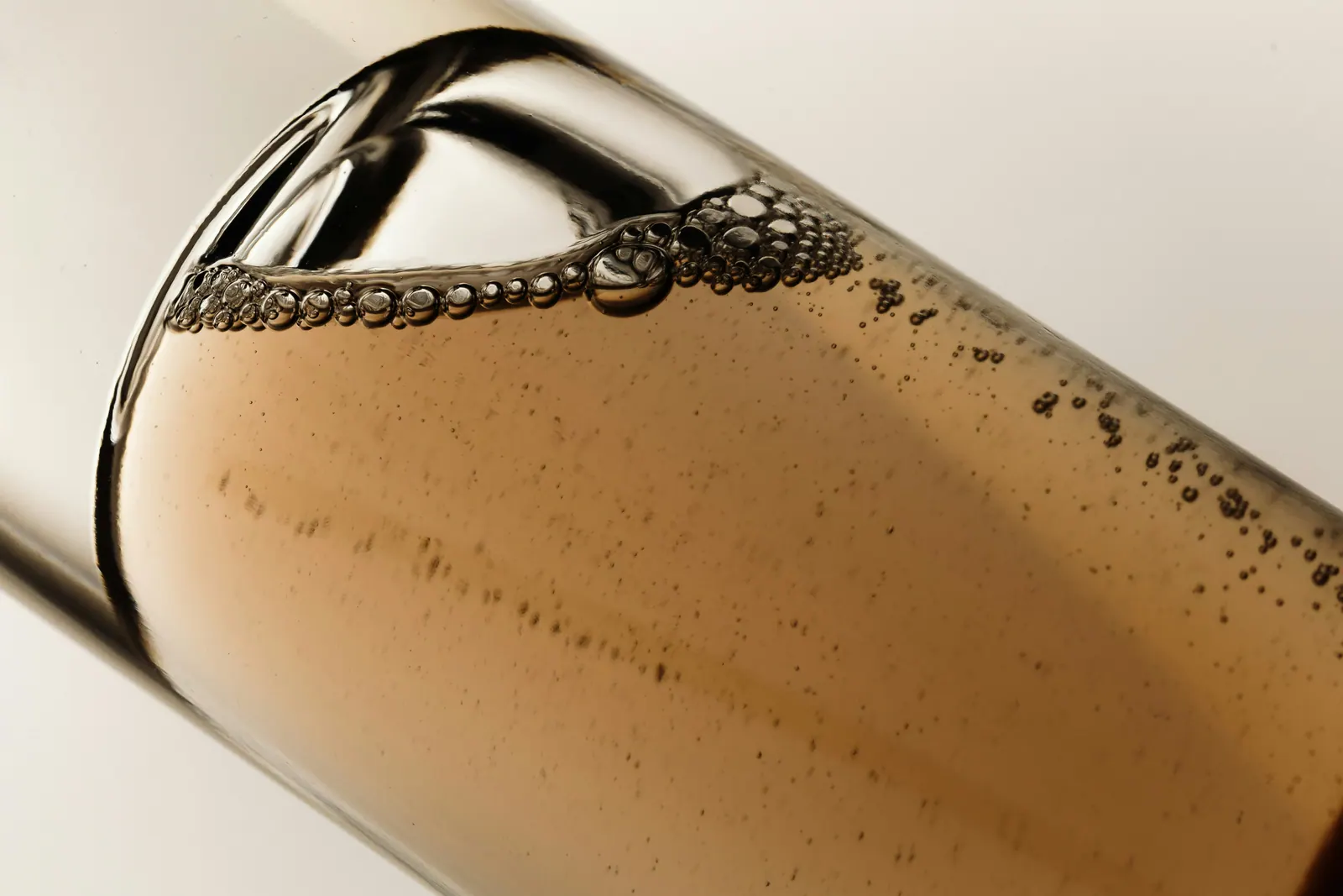 A glass vial of amber serum, lit from the side